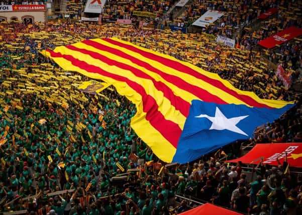Members of the collas sing the Catalan National Anthem 'Els Segadors' as they display an Independence flag.(Photo by David Ramos/Getty Images)