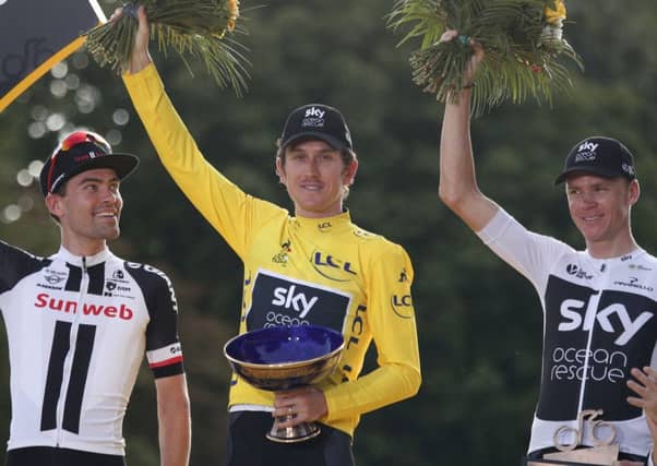 Geraint Thomas, centre, with the Tour de France trophy which was stolen in Birmingham. Picture: Francois Mori/AP