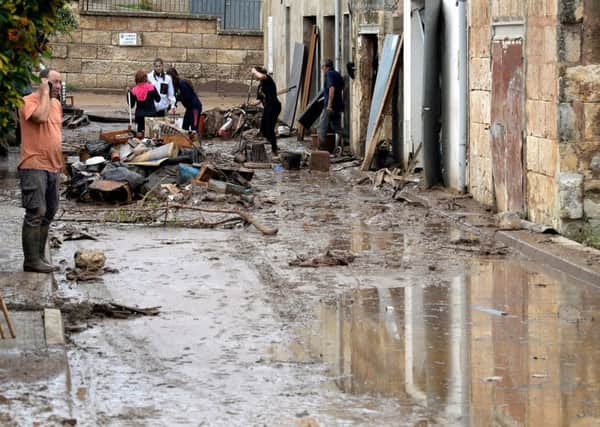 Locals remove debris on a street covered with muddy water in Sant Llorenc des Cardassar, on the Spanish Balearic island of Majorca. Picture: Getty Images