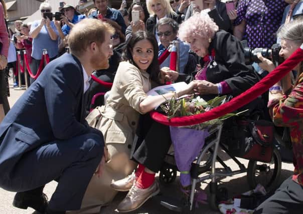 Britain's Prince Harry and Meghan, Duchess of Sussex meet 98-year-old Daphne Dunne during a walkabout outside the Opera House in Sydney. Picture: Paul Edwards/Pool Photo via AP.