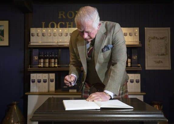 Prince Charles signs the distillery visitors book. Picture: Jane Barlow/PA.