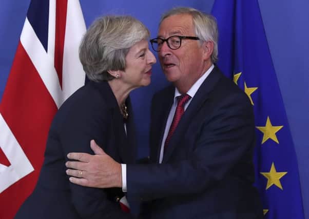 British Prime Minister Theresa May, left, hugs Jean-Claude Juncker, President of the European Commission, as they meet in Brussels, Wednesday, Oct. 17, 2018 when European leaders meet to negotiate on terms of Britain's divorce from the European Union. (AP Photo/Francisco Seco)