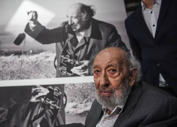 Legendary Turkish photographer Ara Guler stands in front of a picture of him on August 16, 2018 during the opening of the Ara Guler museum in Istanbul. (Photo by OZAN KOSE / AFP)