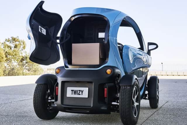 The Twizy is too narrow to sit two abreast, so a passenger sits behind, with legs straddling the front seat. This one-seater cargo version with a tailgate is more practical for shopping and deliveries.