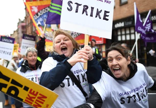 Demonstrators hold placards as they march for equal pay for Glasgow council workers. The Scottish Government wants to significantly boost the number of workers earning the Living Wage. Picture: Jeff J Mitchell/Getty Images