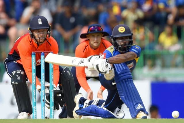 Sri Lanka's Niroshan Dickwella is watched by England wicketkeeper Jos Buttler as he plays a shot. Picture Ishara S Kodikara/AFP/Getty