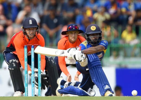 Sri Lanka's Niroshan Dickwella is watched by England wicketkeeper Jos Buttler as he plays a shot. Picture Ishara S Kodikara/AFP/Getty