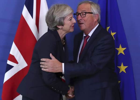 British Prime Minister Theresa May hugs Jean-Claude Juncker, President of the European Commission, as they meet in Brussels, Picture; AP