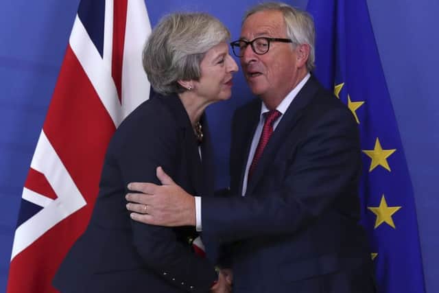 British Prime Minister Theresa May hugs Jean-Claude Juncker, President of the European Commission, as they meet in Brussels, Picture; AP