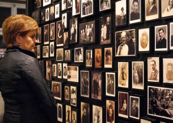 Nicola Sturgeon views photographs of victims of the Holocaust during her visit to the Auschwitz-Birkenau camp