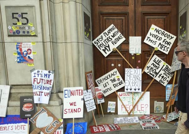 People walk past placards left at the Department of International Trade during a march calling for a People's Vote on the final Brexit deal, in central London. Picture: NIKLAS HALLE'N/AFP/Getty Images.
