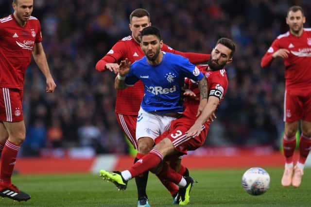 Graeme Shinnie clashes with Daniel Candeias. Pictrure: SNS Group