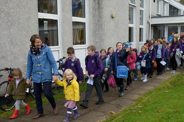 Head teacher Pamela Hill leads the children away from their old school for the last time as they move to the community built New Strontian School on the Ardnamurchan Peninsula, Highland. Picture: SWNS