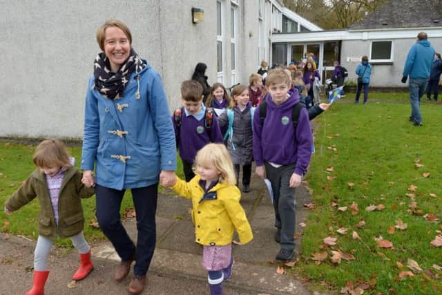 Head teacher Pamela Hill leads the children away from their old school for the last time. Picture: SWNS