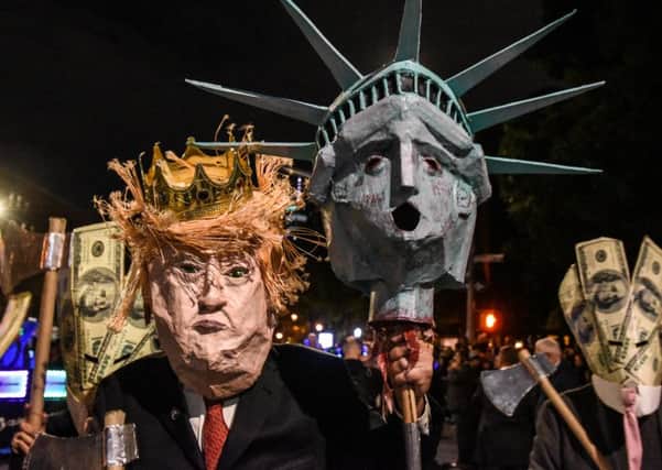 A Halloween-version of Donald Trump carries an axe and Libertys head on a spike during a parade in New York (Picture: Stephanie Keith/Getty Images)