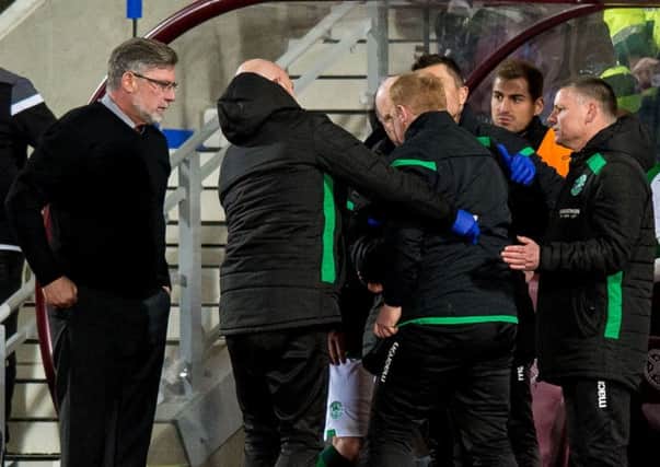 Craig Levein looks on as 
Hibs manager Neil Lennon is helped to his feet after appearing to be struck by an object. Picture: Ross Parker/SNS
