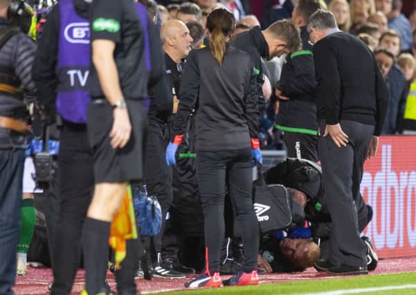 Hibernian manager Neil Lennon on the ground after appearing to be struct by an object from the crowd. Picture: SNS Group