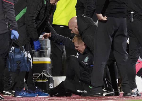 Hibernian manager Neil Lennon is helped to his feet after appearing to be struct by an object from the crowd