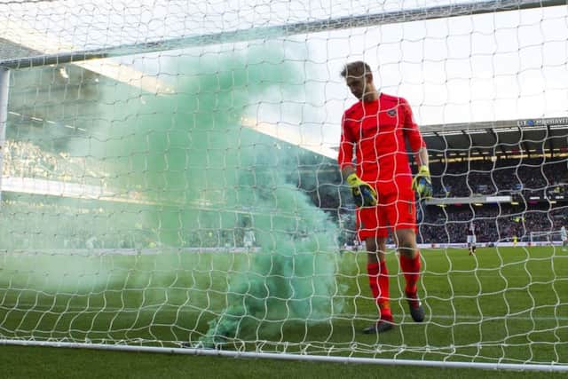Hearts Zdenek Zlamal approaches a flare in his net. Picture: SNS.