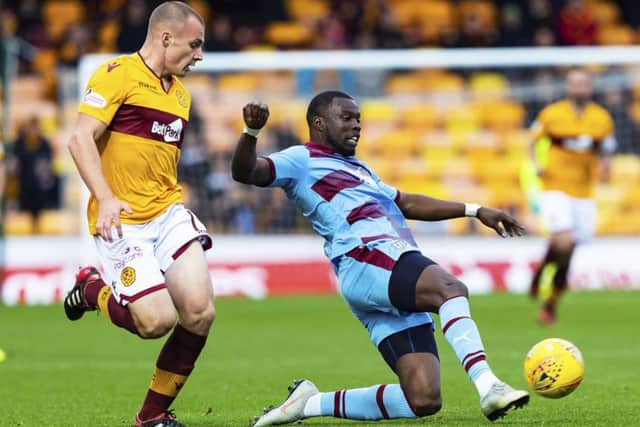 Dundee's Genseric Kusunga competes with Motherwell midfielder Liam Grimshaw. Picture: SNS