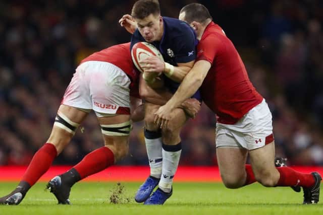 Scotland's Huw Jones is tackled by Wales' Cory Hill and Ken Owens. Picture: David Davies/PA Wire