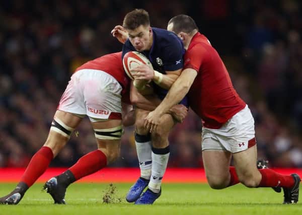 Scotland's Huw Jones is tackled by Wales' Cory Hill and Ken Owens. Picture: David Davies/PA Wire