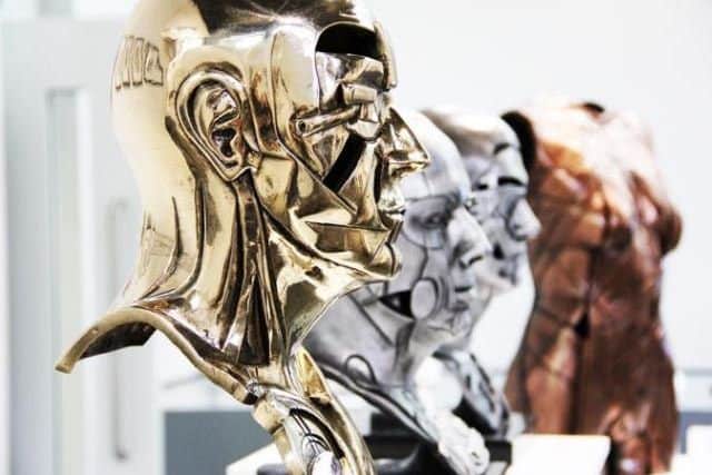 Motor Head, polished bronze, and other head and body cast sculptures