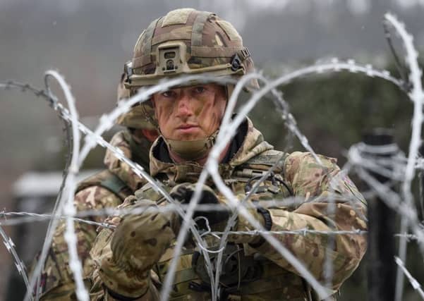 A member of the British Army Royal Engineers rigs up a barbed wire defence in Norway. (Photo by Leon Neal/Getty Images)