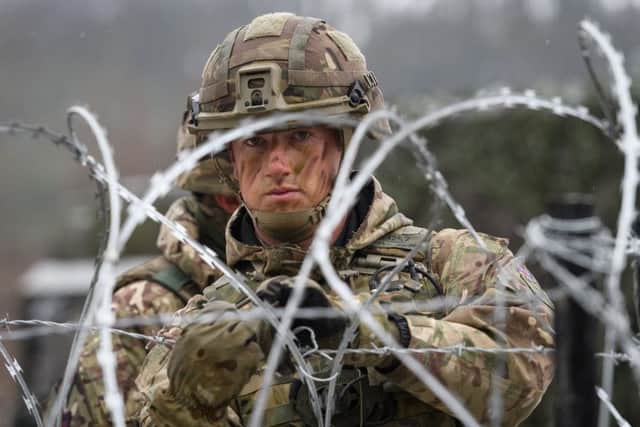 A member of the British Army Royal Engineers rigs up a barbed wire defence in Norway. (Photo by Leon Neal/Getty Images)