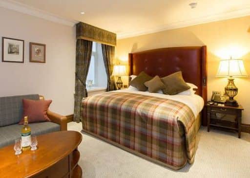 Plaid, leather and copper touches in a bedroom at the Station Hotel, Aberlour