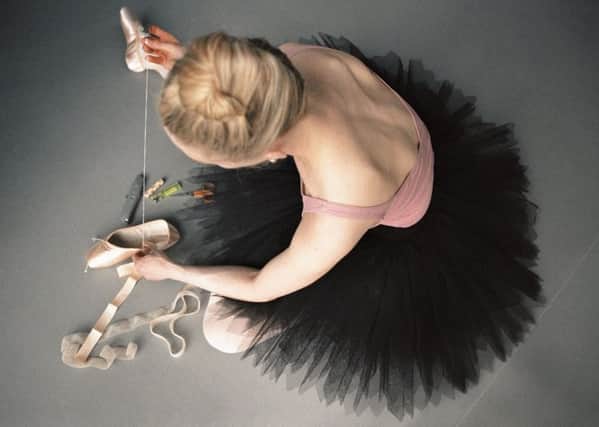 A dancer breaking in a new pair of pointe shoes