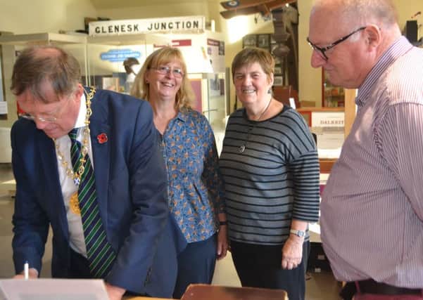 Provost Peter Smaill signs the visitors book at Dalkeith Museum as volunteers Helen Gordon, Norma McNeill and Norman Brett look on.