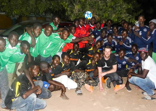 Andrew Jenkin, a founding trustee of Africa on the Ball, with some of the people the charity has helped.