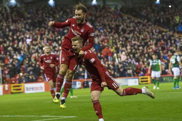 Aberdeens Stevie May leaps on goalscorer Gary Mackay-Steven at a blustery Pittodrie. Picture: Ross Parker/SNS