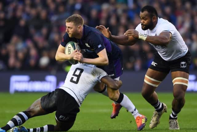Scotland's Finn Russell looks to offload as he's tackled by Fiji's Frank Lomani. Pic: SNS/SRU/Gary Hutchison