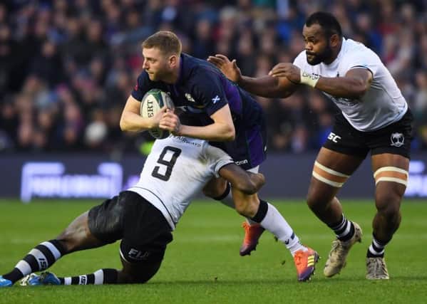 Scotland's Finn Russell looks to offload as he's tackled by Fiji's Frank Lomani. Pic: SNS/SRU/Gary Hutchison