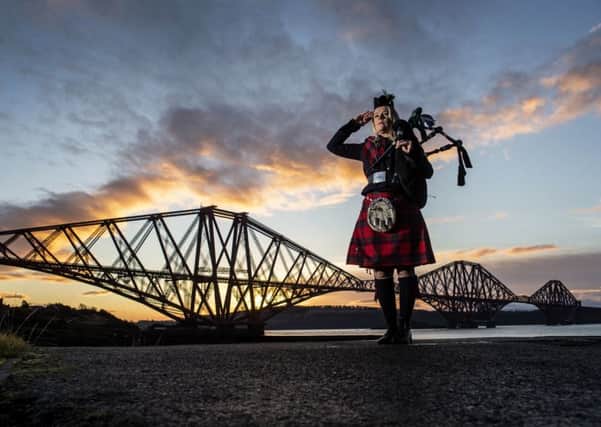 Piper Louise Marshall at dawn alongside the Forth Bridge at North Queensferry on the 100th anniversary of the signing of the Armistice which marked the end of the First World War. Picture: PA Wire