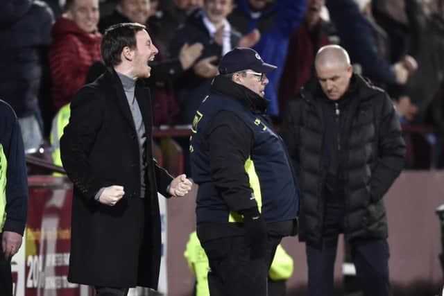 Hearts head coach Ian Cathro celebrates after Don Cowie makes it 3-1 as Rangers manager Mark Warburton looks dejected. Picture: SNS