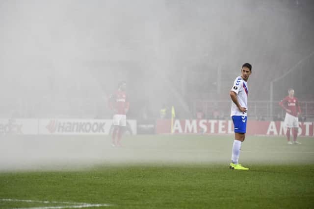 Nikola Katic looks on as smoke billows around the Otkritie Arena after fireworks were let off by Spartak Moscow fans. Picture: AFP/Getty Images