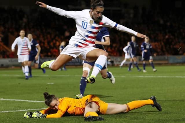 USA striker Carli Lloyd leaps to avoid Lee Alexander as the Scots gave the World Cup holders a stiff test in Paisley last night. Picture: Getty Images