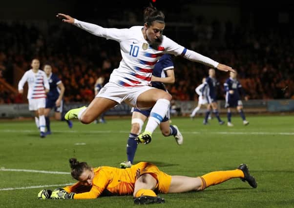 USA striker Carli Lloyd leaps to avoid Lee Alexander as the Scots gave the World Cup holders a stiff test in Paisley last night. Picture: Getty Images