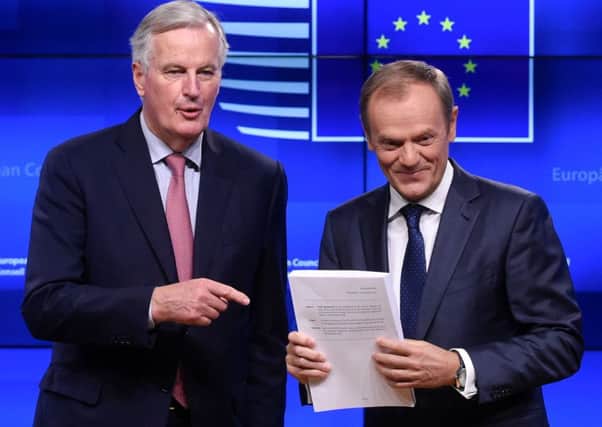 Michel Barnier hands the draft agreement to Donald Tusk. Picture: John Thys/Getty