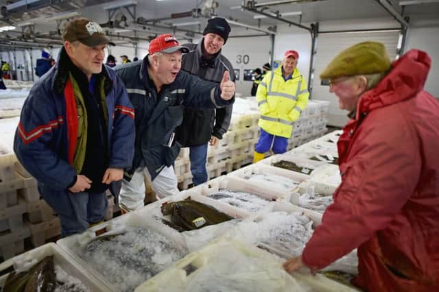 ABERDEEN, SCOTLAND - NOVEMBER 25: Buyers at Peterhead fish market joke with one another during the sale on November 25, 2015 in Peterhead, Scotland. Recent negotiations could see an increase in North Sea fishing quotas covering several key species for the Scottish fishing industry, including North Sea cod, haddock, saithe and herring. Recent scientific advice recommends an increase in quotas for North Sea cod and North Sea haddock reflecting the healthy state of many of the Scottish fishing fleets most important fish stocks. (Photo by Jeff J Mitchell/Getty Images)