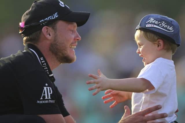 Danny Willett celebrates with his young son after his victory in the World Tour Championship in Dubai. Picture: AP Photo/Kamran Jebreili