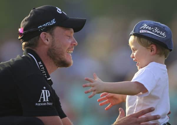 Danny Willett celebrates with his young son after his victory in the  World Tour Championship in Dubai. Picture: AP Photo/Kamran Jebreili