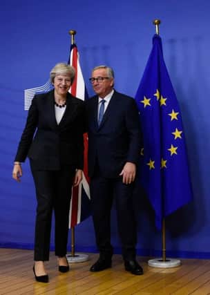 EU Commission President Jean-Claude Juncker and British Prime Minister Theresa May leave after a press briefing. (Photo by JOHN THYS / AFP)