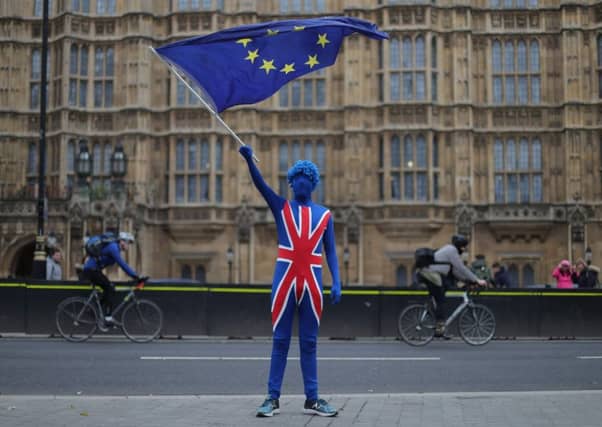 An anti-Brexit demonstrator dressed in a Union flag suit waves an EU flag outside the Houses of Parliament. Picture: AFP/Getty