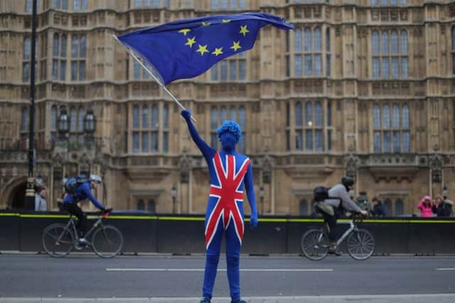 An anti-Brexit demonstrator dressed in a Union flag suit waves an EU flag outside the Houses of Parliament. Picture: AFP/Getty