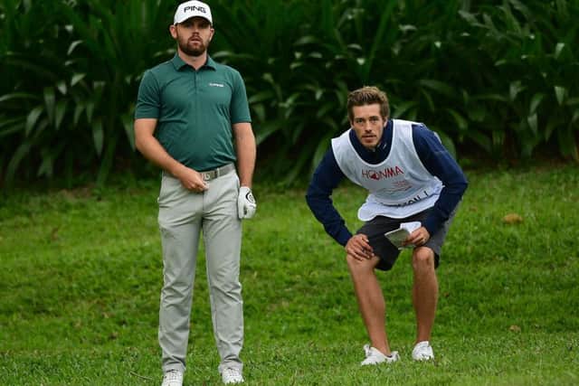 Liam Johnston, pictured working out a plan of attack with his caddie Ross Noon, safely made the cut in the Honma Hong Kong Open. Picture: Getty Images