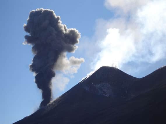 A plume of smoke billows from the Italian volcano of Mount Etna, which studies  using sensitive instruments have shown is very gradually moving and expanding in between its frequent eruptions